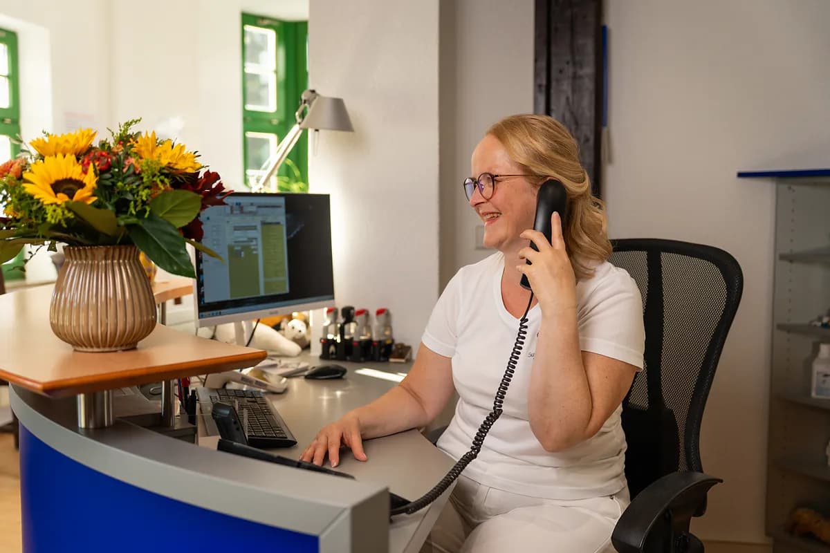 Mitarbeiterin vereinbart am Empfang telefonisch einen Termin